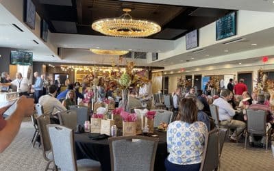 Lots of people at tables in a lobby area