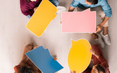 group of four friends holding up colored text bubbles